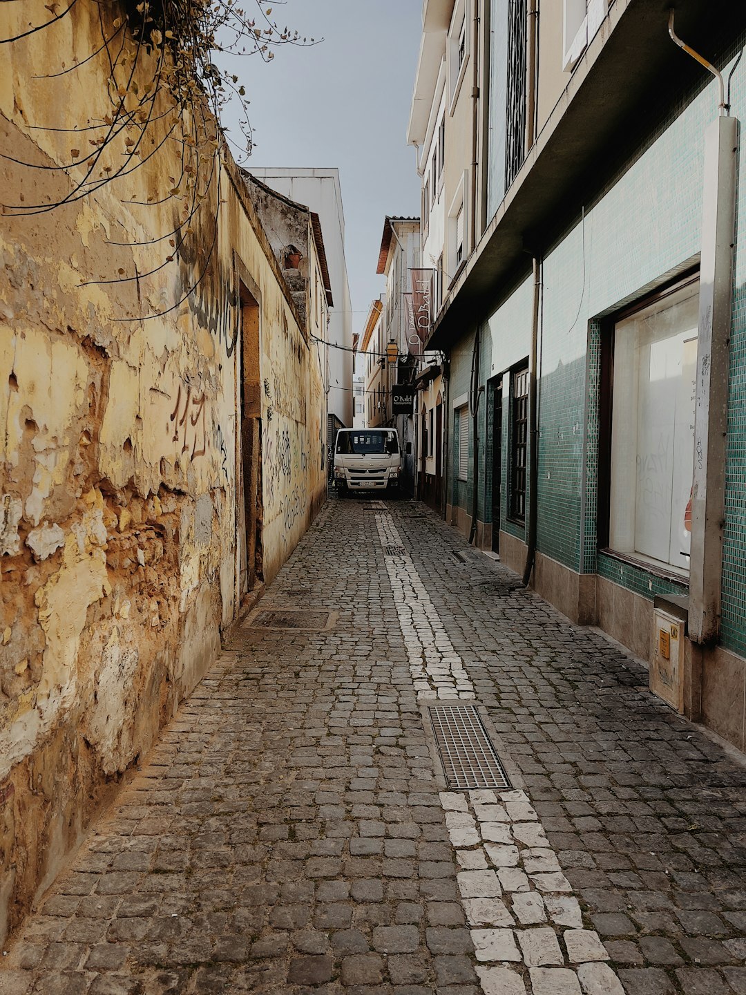 Turistas numa rua histórica de calçada portuguesa